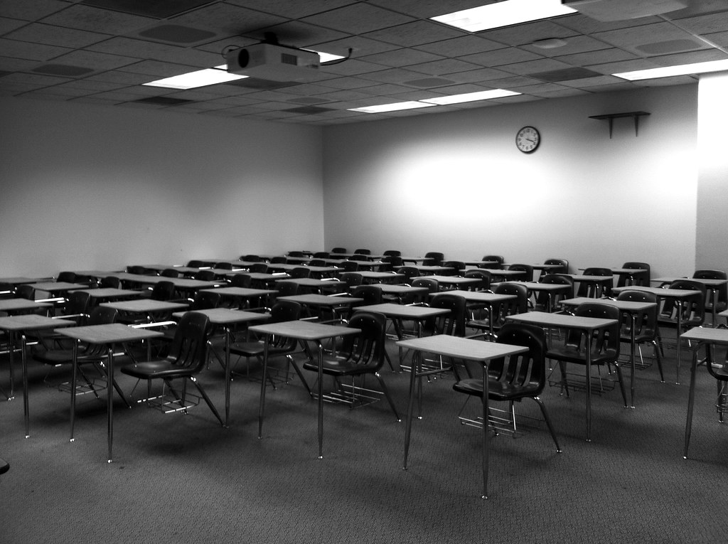 An empty classroom with rows of desks
