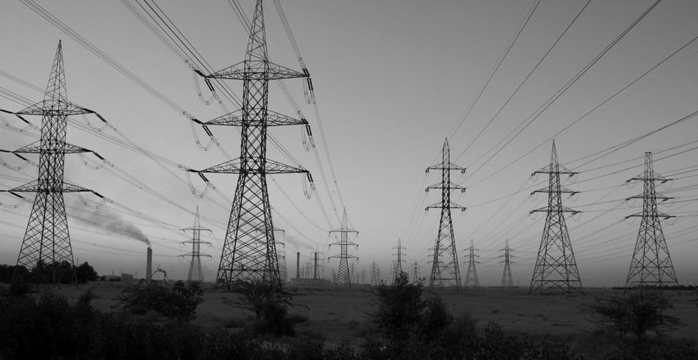 Transmission lines across a power grid at dusk